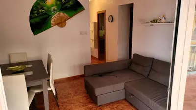 a living room with a couch and a table at appartement pied dans l eau in El Brosquil