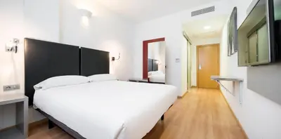 a bedroom with a large white bed in a room at Ilunion Aqua 3 in Valencia