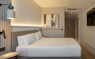 a lobby with white furniture and large windows at Ilunion Valencia 3 in Valencia