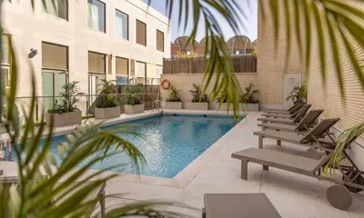 a row of chairs and a swimming pool at Ilunion Valencia 3 in Valencia