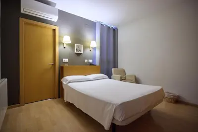 a bedroom with a large bed and a yellow door at Hotel De Jerica in Jérica