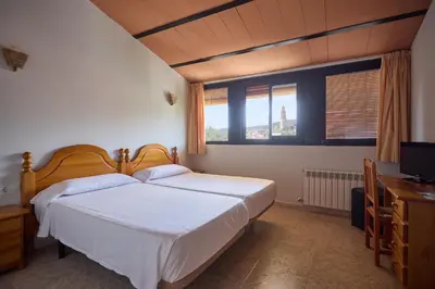 a bedroom with a large bed and a television at Hotel De Jerica in Jérica