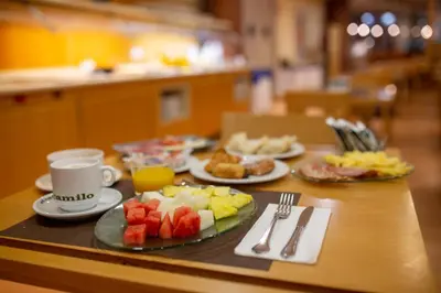 a table with plates of food and a cup of coffee at Flag Hotel Valencia in Masalfasar