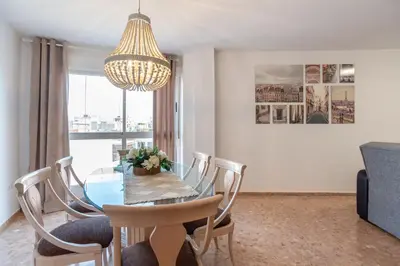a dining room with a table and chairs and a chandelier at Magnifico apartamento en Burriana in Burriana