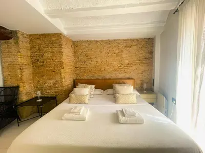 a large bed in a room with a brick wall at Valencia Luxury - Boutique El Carmen in Valencia