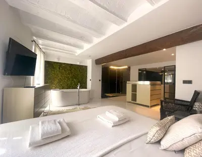 a bedroom with a large white bed and a bathroom at Valencia Luxury - Boutique El Carmen in Valencia