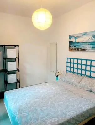 a bedroom with a blue bed and a lamp at Apartamento en la playa las arenas +Wifi+AC in Valencia