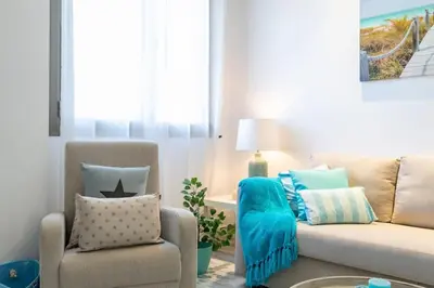 a living room with a couch and a chair at ApartUP Patacona Azzure in Valencia
