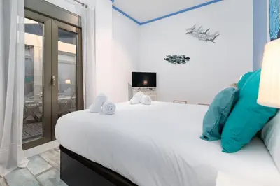 a bedroom with a large white bed and a window at ApartUP Patacona Azzure in Valencia