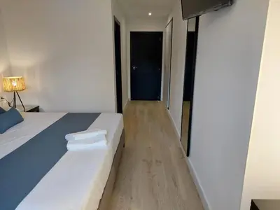 a bedroom with two beds and a hallway at Hostal GARDEN ROUS in Paiporta