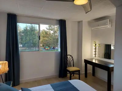 a bedroom with a bed and a desk and a window at Hostal GARDEN ROUS in Paiporta