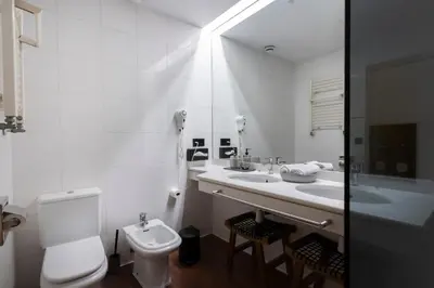 a white bathroom with a toilet and a sink at YOU & CO. J. Botánico Boutique in Valencia