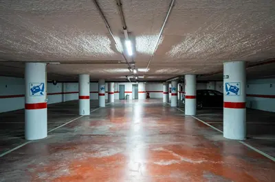 an empty parking garage with white columns and a parking lot at Hotel Bartos in Almussafes