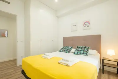 a bedroom with a yellow bed with towels on it at Modern, Stylish Apartment with balcony in Valencia