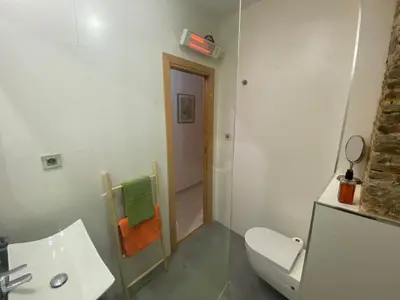 a bathroom with a white toilet and a sink at Your Valencia Home in Valencia