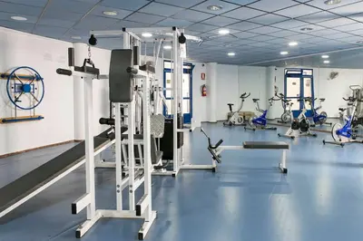 a gym with several tread machines in a room at ApartUP Patacona Oriental in Valencia