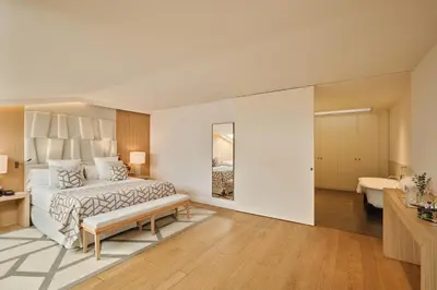 a bedroom with a large bed and a bathroom at Hospes Palau de La Mar, Valencia, a Member of Design Hotels in Valencia