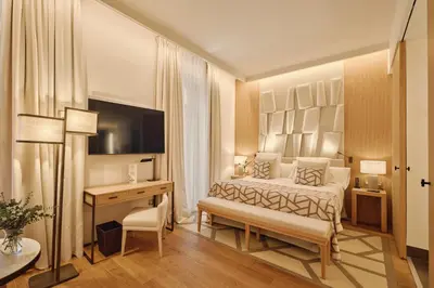 a bedroom with a bed and a desk and a television at Hospes Palau de La Mar, Valencia, a Member of Design Hotels in Valencia