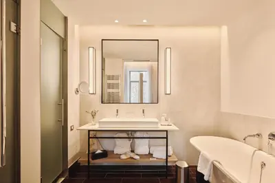 a bathroom with a sink and a tub and a mirror at Hospes Palau de La Mar, Valencia, a Member of Design Hotels in Valencia