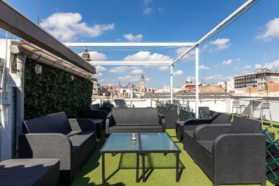 a patio with chairs and a table on a roof at Sweet Hotel Continental in Valencia