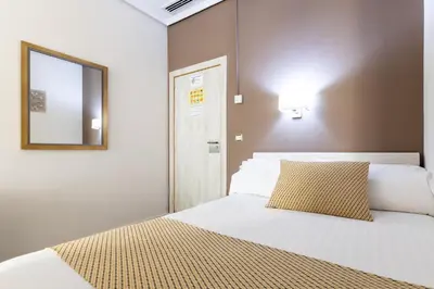 a bedroom with a white bed with a mirror and a mirror at Sweet Hotel Continental in Valencia