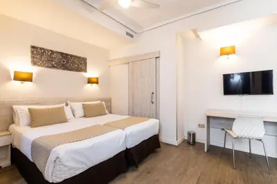 a hotel room with a bed and a tv at Sweet Hotel Continental in Valencia