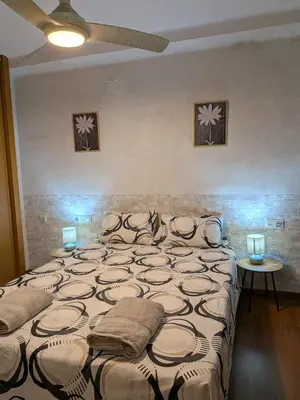 a bedroom with a large bed with two lamps on it at Estrella azul/ Blue star in Puerto de Sagunto