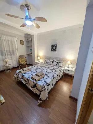 a bedroom with a large bed and a ceiling fan at Estrella azul/ Blue star in Puerto de Sagunto