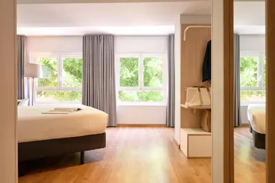a bedroom with a bed and two windows at Rooms Ciencias in Valencia