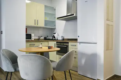 a kitchen with a table and chairs and a refrigerator at Anka Beach Apartment Patacona in Valencia