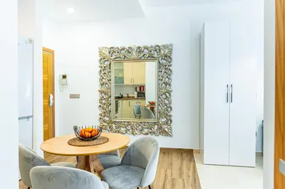 a dining room with a table and chairs and a mirror at Anka Beach Apartment Patacona in Valencia