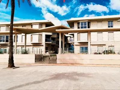 a building with a palm tree in front of it at Anka Beach Apartment Patacona in Valencia
