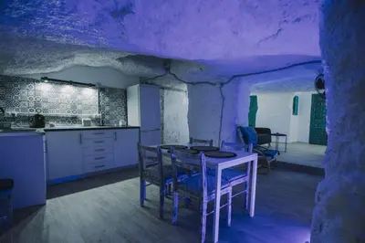 a kitchen with a table and chairs in a room at Preciosa casa-cueva con bañera in Paterna