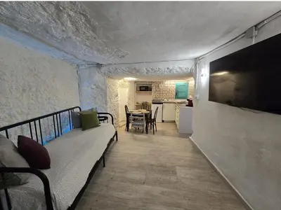 a living room with a couch and a television on a wall at BONITA CASA CUEVA CON JACUZZI in Paterna