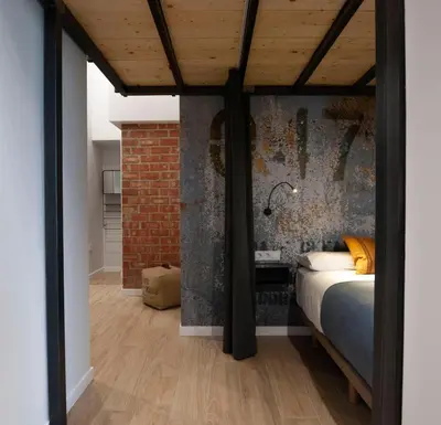 a bedroom with a bed and a brick wall at Loft con carácter en Valencia. in Valencia