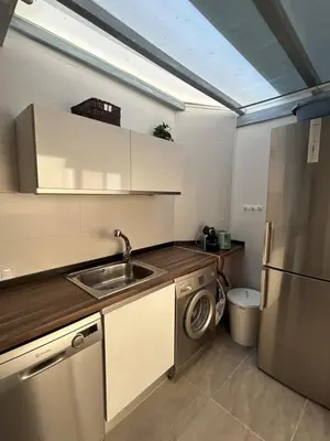a kitchen with a sink and a dishwasher at Acogedora y moderna casa en pueblo in Serra
