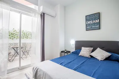 a bedroom with a blue bed and a balcony at Apartamento nuevo cerca de la playa y del centro in Valencia