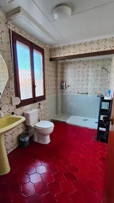 a bathroom with a white toilet and a red floor at Pensión Benavente AP-7 3min coche Playa 5 min Self check-in 24h in Moncófar