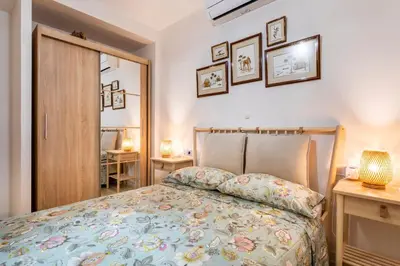 a bedroom with a bed and two tables with lamps at Cala Brull - Acogedor apartamento a 10 minutos de la playa in Valencia