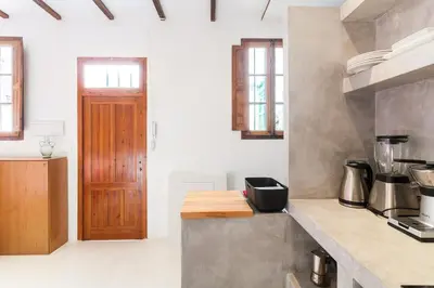 a kitchen with a counter and a wooden door at Casita artista en bello edificio barrio Ruzafa in Valencia