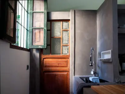 a kitchen with a wooden door and a sink at Casita artista en bello edificio barrio Ruzafa in Valencia