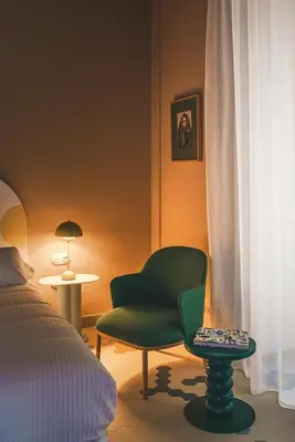 a bedroom with a green chair and a bed at Casa Clarita in Valencia