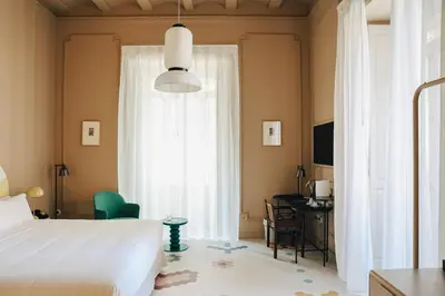 a bedroom with a bed and a desk and a window at Casa Clarita in Valencia