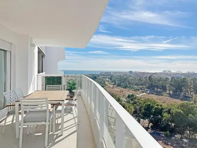 a balcony with a wooden table and chairs on it at Global Vacacional, Moderno apartamento de dos terrazas con vistas al mar y a la montaña in Canet de Berenguer