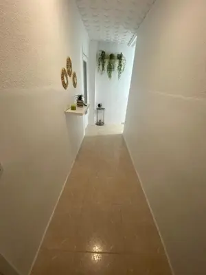 a hallway with white walls and a tile floor at Appartement Célia in Algemesí