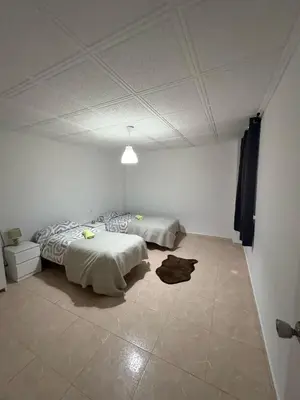 a bedroom with two beds and a tiled floor at Appartement Célia in Algemesí