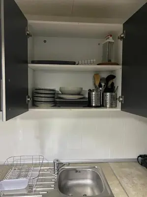 a kitchen with a sink and a shelf with dishes at Appartement Célia in Algemesí