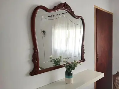 a mirror on a wall with a vase on a shelf at La Casica in Chulilla