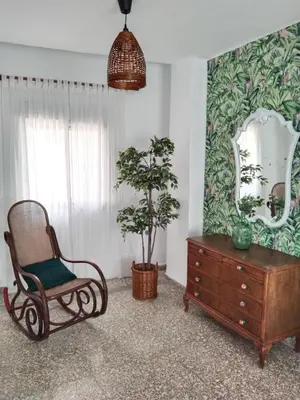 a room with a chair and a dresser and a mirror at La Casica in Chulilla