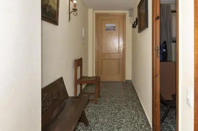 a hallway with a room with a door and a chair at Levante, 6-J in Cullera
